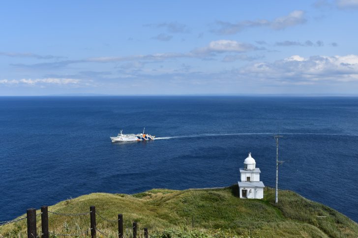 利尻島のペシ岬から見下ろすフェリーと灯台